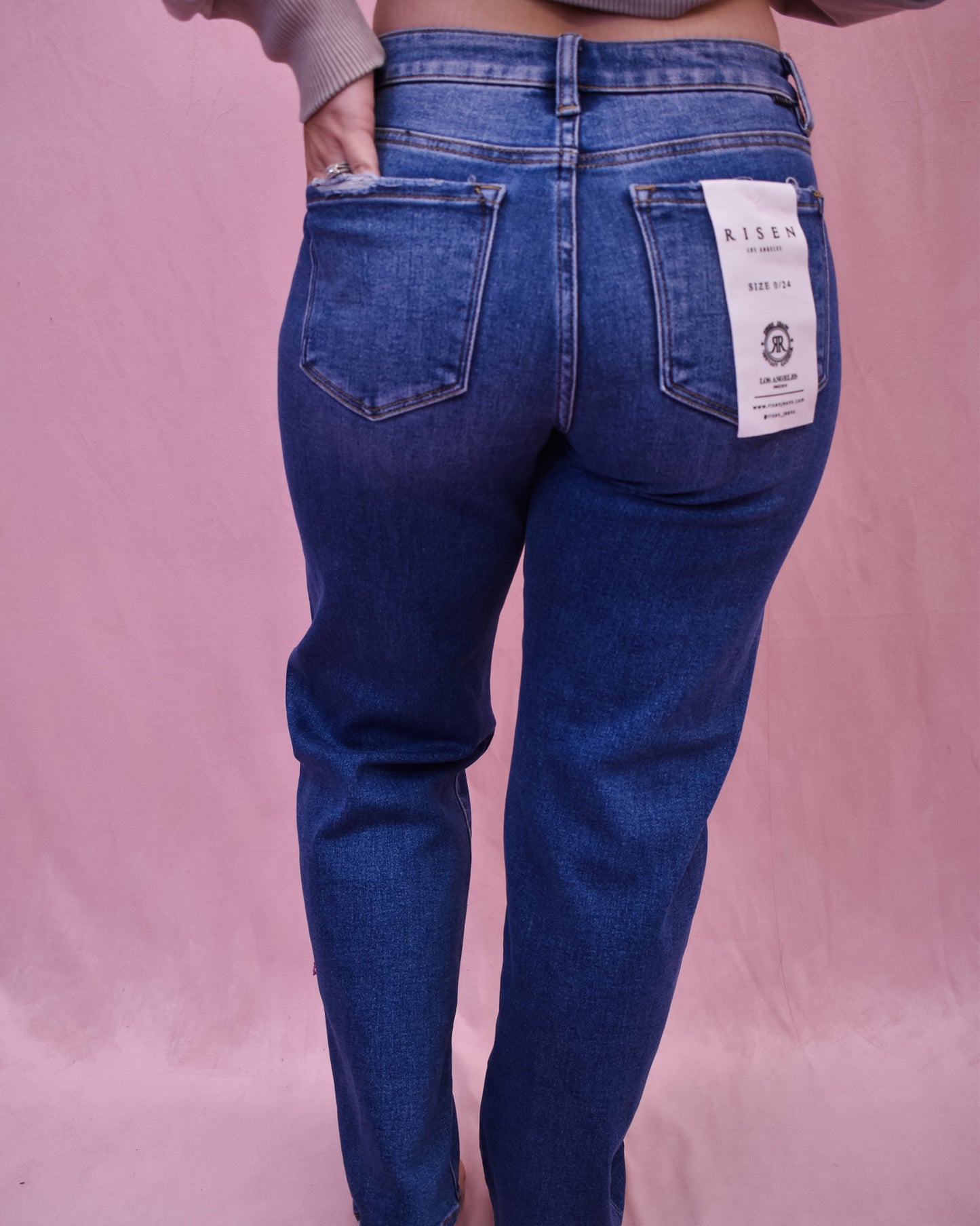 Blue jeans with a brand label on a pink background