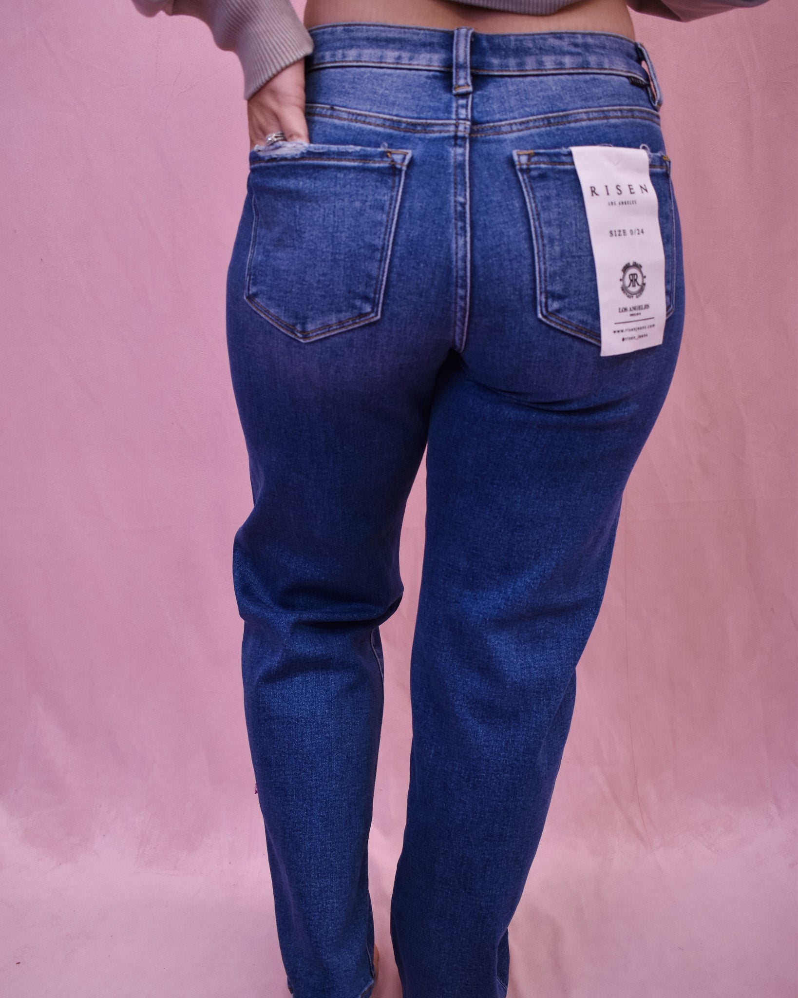 Blue jeans with a brand label on a pink background