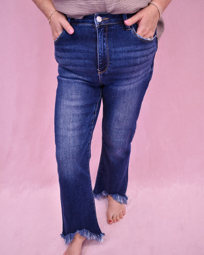 Person wearing blue jeans on a pink background