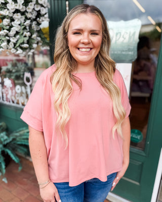 a rose colored scuba style top with a hi-low split hem.