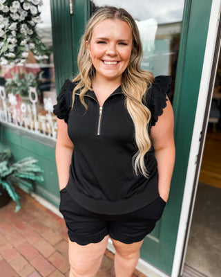 Soft Luxe-Cotton two-piece short set featuring a ruffled half-zip sweatshirt and matching shorts. A comfortable, feminine lounge set perfect for travel, errands, and everyday casual style.