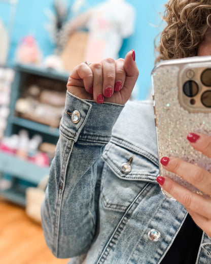 Person wearing a denim jacket with a blurred background
