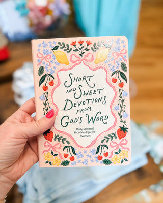 Book titled 'Short and Sweet Devotions from God's Word' held by a hand with a colorful cover.