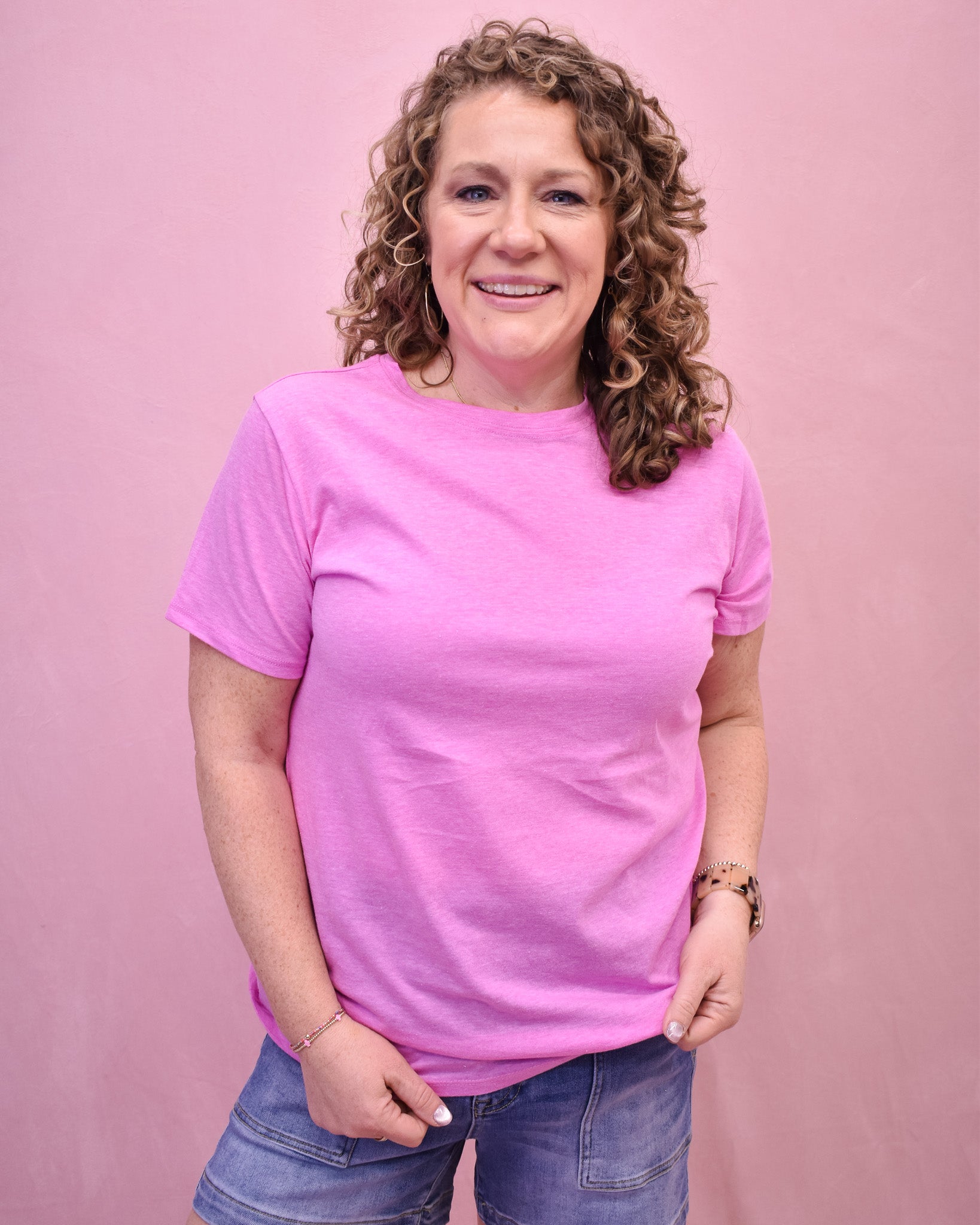 Woman wearing a pink t-shirt against a pink background