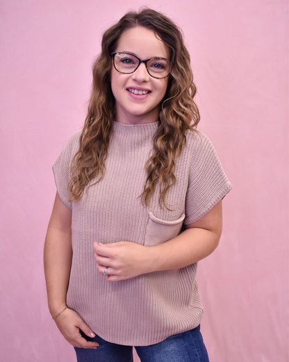 Woman wearing a pink sweater against a pink background