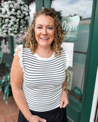 a sleeveless ruffled striped sweater top in black stripes on an ivory top