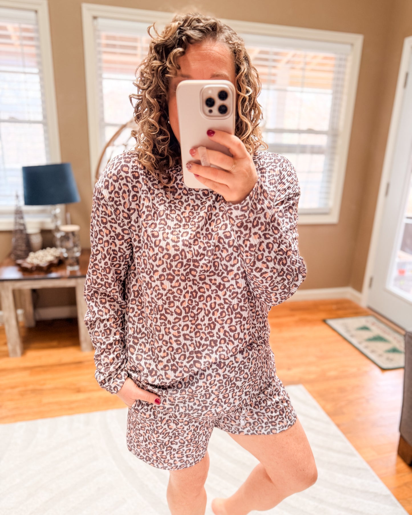 Person wearing a leopard print pajama set taking a mirror selfie.