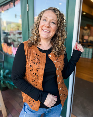 a sleeveless suede laser cutout button down vest in a cognac color.