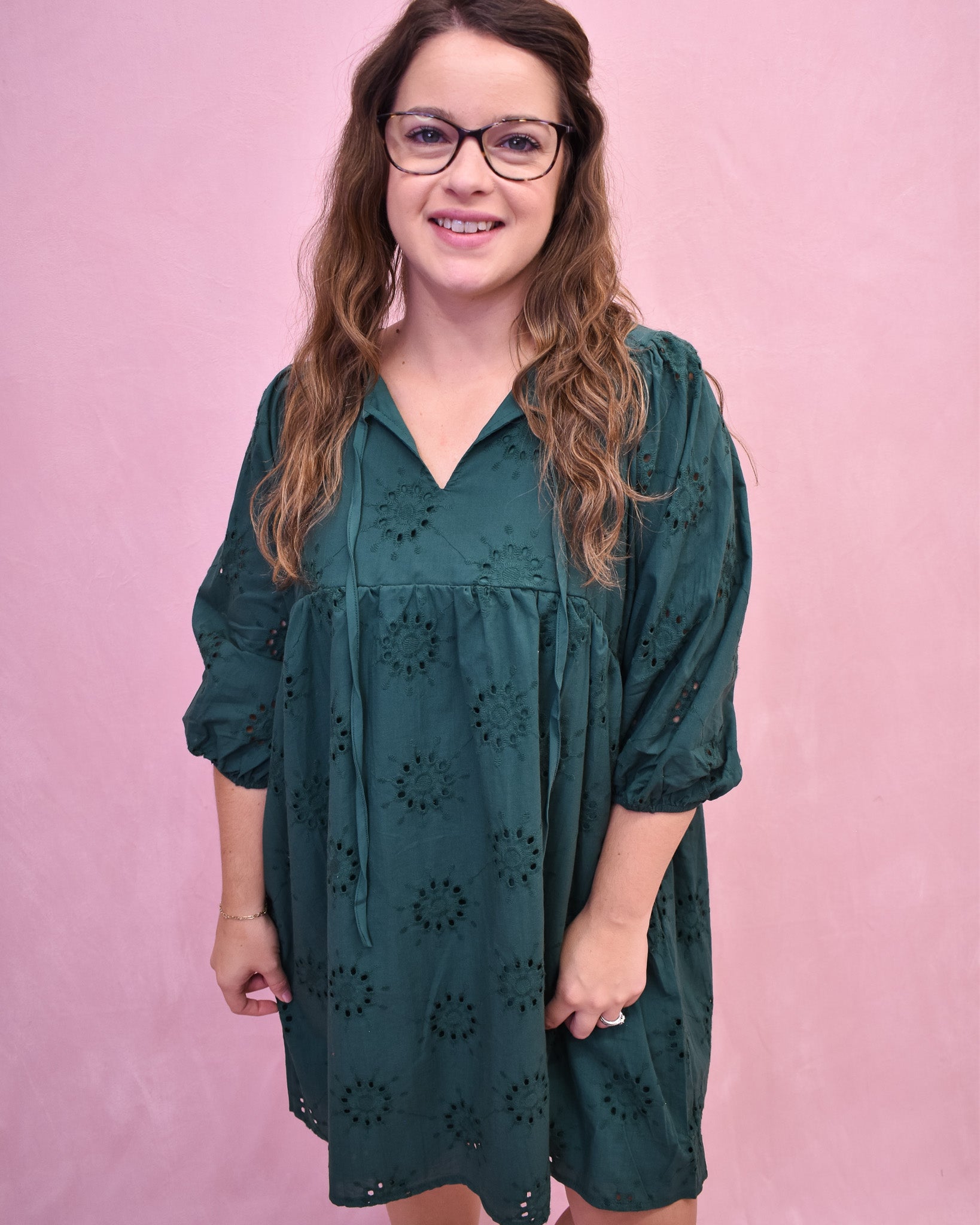 Woman wearing a green dress with a pink background