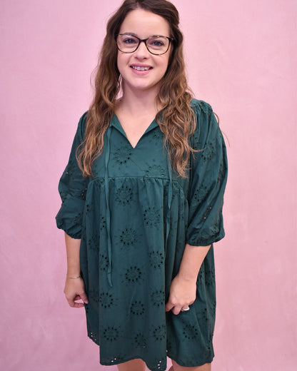 Woman wearing a green dress with a pink background