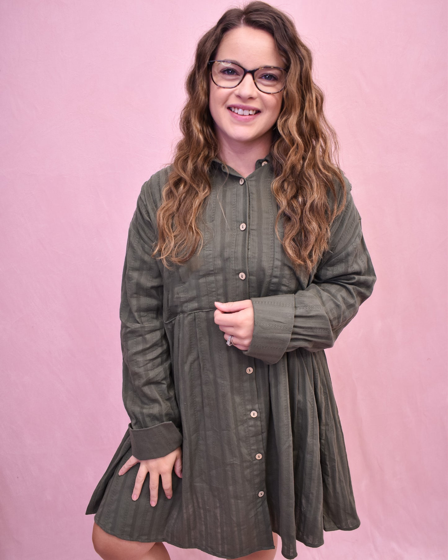 Woman wearing a green dress with a pink background