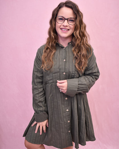 Woman wearing a green dress with a pink background