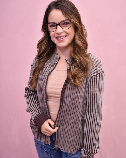 Woman wearing a striped shirt over a pink top on a pink background