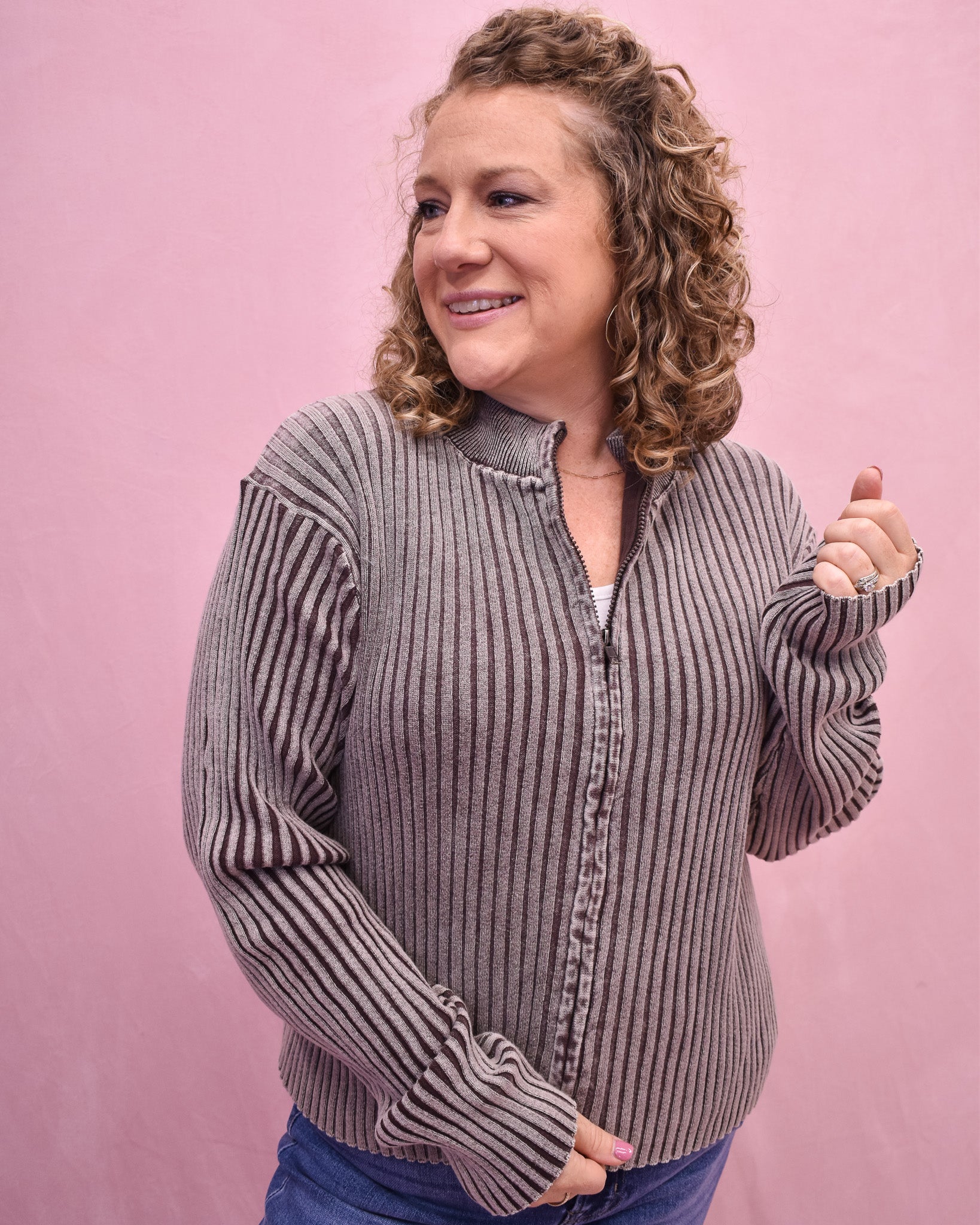 Woman wearing a striped sweater against a pink background