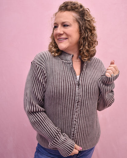Woman wearing a striped sweater against a pink background